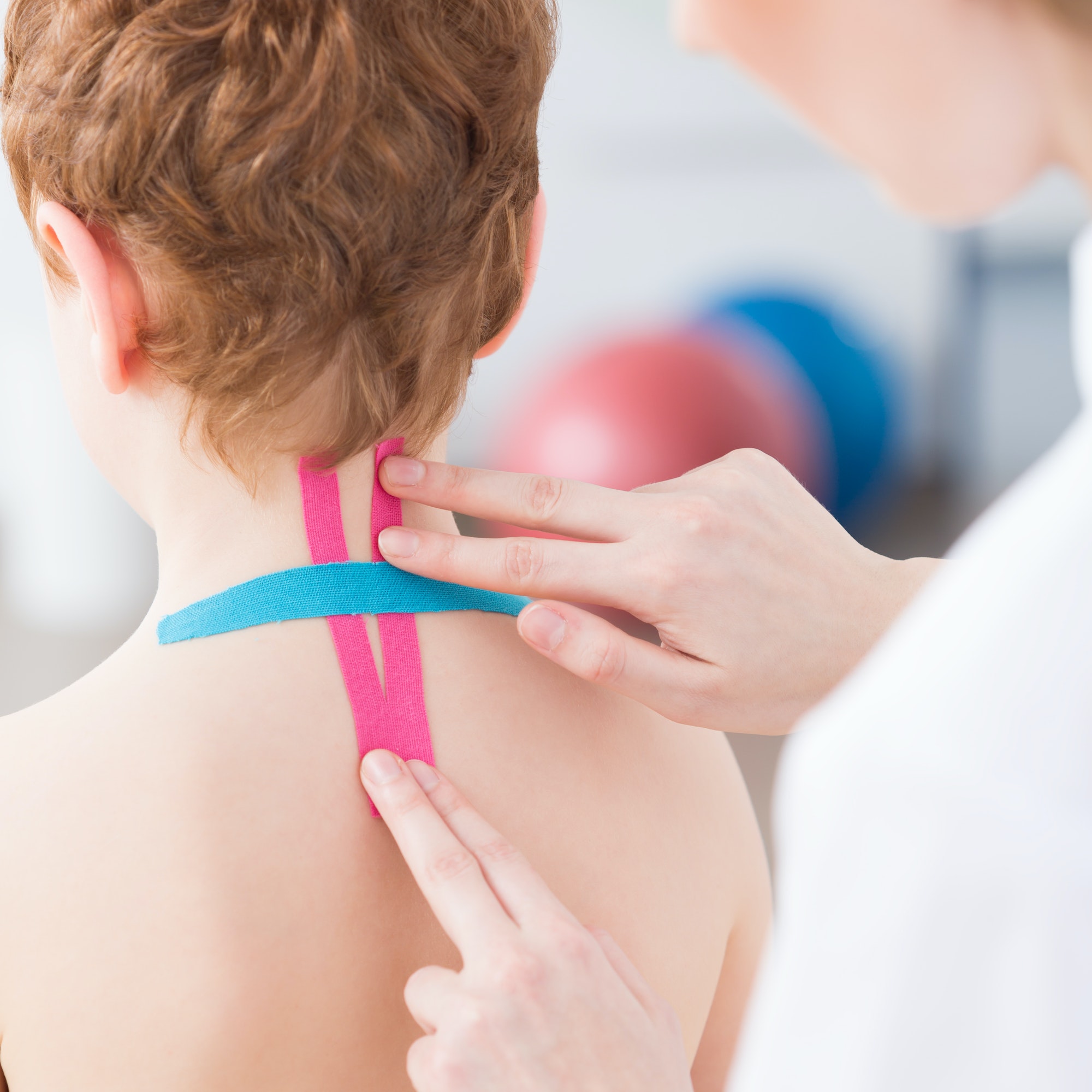 Physiotherapist applying kinesiology tapes